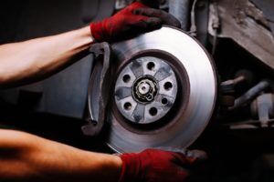 mechanic working on brake pads and rotors