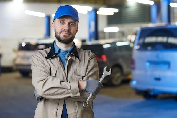 Auto mechanic with spanner standing in auto repair shop